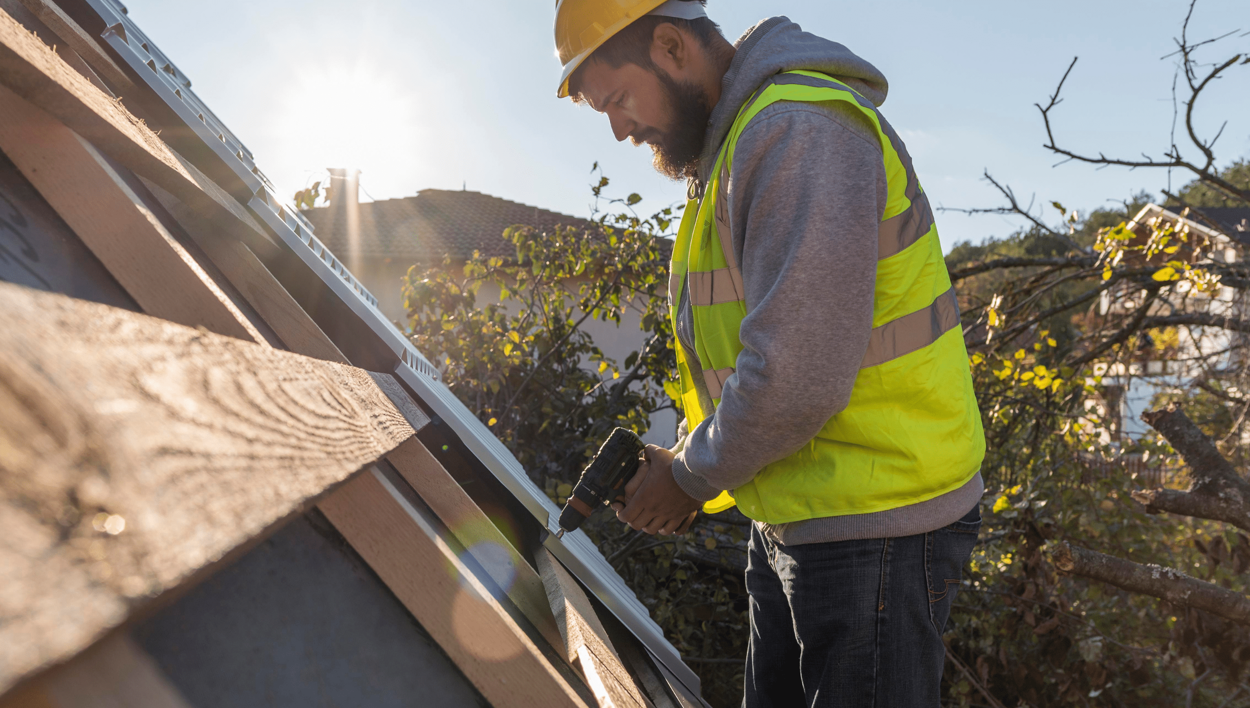 A man repairing a roof in Michigan that was damaged by wind